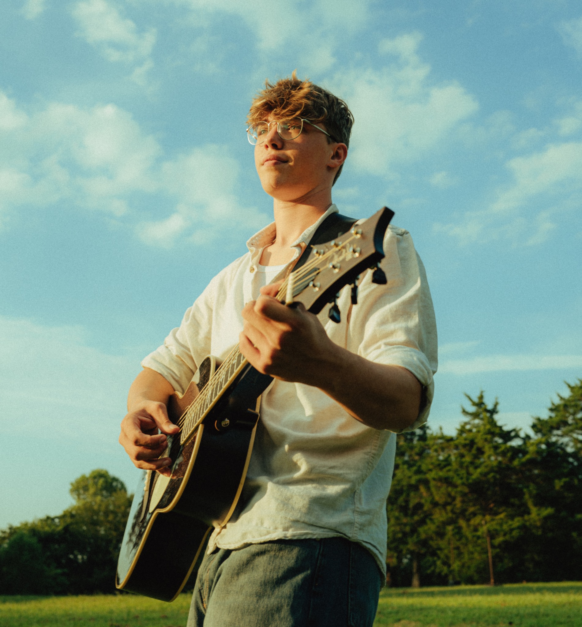 Kadin Alexander outdoors with his acoustic guitar